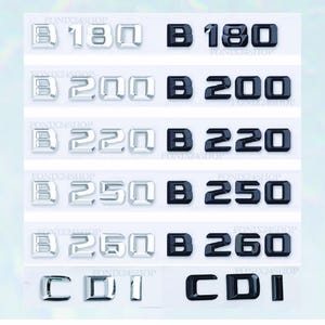 May include: A selection of car badges in silver and black. The badges display the numbers 180, 200, 220, 250, and 260, alongside the letter "B" and the letters "CDI". The text "FONIX24SHOP" is also present.