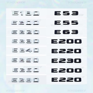 Puede incluir: Colección de emblemas de modelos de coches, incluyendo E180, E200, E220, E230, E240, E250, E280, E53, E55 y E63. Los emblemas son plateados y negros, dispuestos sobre un fondo blanco. El texto "FONIX24SHOP" es visible.