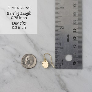 Image of earring next to ruler for scale. Earring length is 0.75 inch and disc size is 0.3 inch.