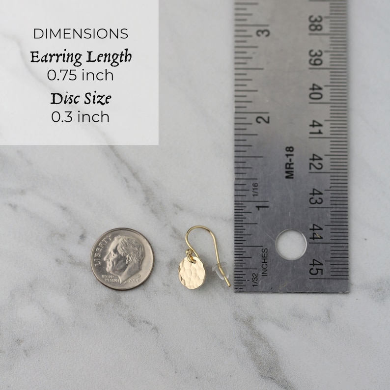 Image of earring next to ruler for scale. Earring length is 0.75 inch and disc size is 0.3 inch.