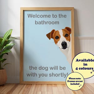 May include: A framed print with a light blue background and a Jack Russell Terrier illustration. Text reads "Welcome to the bathroom, the dog will be with you shortly!" Additional text states "Available in 4 colours" and "Frames are not included."