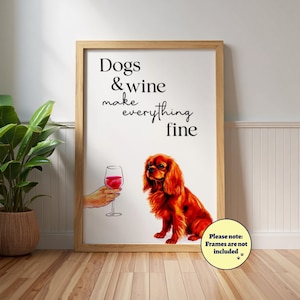 Op de afbeelding: Een ingelijste kunstdruk met een Cavalier King Charles Spaniel en een hand die een wijnglas vasthoudt. De tekst luidt: "Dogs & wine make everything fine." Het kunstwerk is geplaatst in een houten frame.