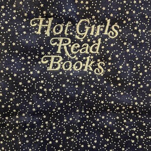 Puede incluir: Tela azul marino con un patr&oacute;n de estrellas blancas. La frase "Hot Girls Read Books" est&aacute; bordada en una fuente cursiva. La tela tiene una textura suave y aterciopelada.