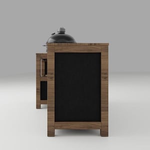 May include: A wooden outdoor kitchen island with a dark brown wood grain finish and black rectangular panels. The structure features a side shelf and a black dome-shaped grill lid resting on the top surface, showcasing a sturdy frame construction.