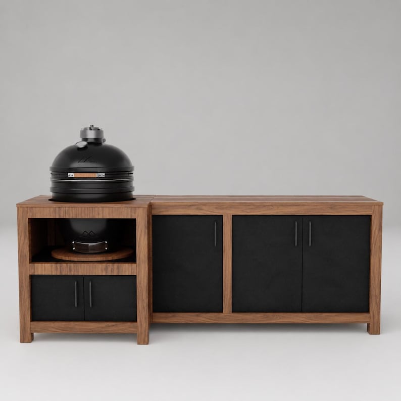 May include: A black ceramic kamado-style grill sits on a wooden outdoor kitchen island. The island features a natural wood frame with matte black cabinet doors and vertical handles, providing storage space beneath the grill and to the side.