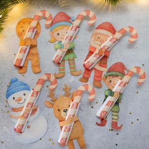 Peut inclure: Découpages en papier sur le thème de Noël représentant un bonhomme en pain d'épices, un elfe, le Père Noël, un bonhomme de neige, un renne et un autre elfe, chacun tenant une canne en sucre. Les cannes en sucre sont rayées rouge et blanc et ont du texte.