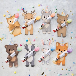 Könnte beinhalten: Acht ausgestanzte Papierfiguren von Tieren, darunter Eule, Hirsch, Wolf, Wildschwein, Bär, Dachs, Hase und Fuchs. Jedes Tier trägt einen bunten Partyhut und hält eine weiße Röhre mit der Aufschrift "du bist eingeladen" und einem kleinen Luftballon.