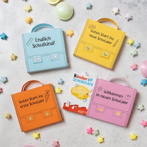 Può includere: Quattro piccole scatole regalo in carta a forma di zainetti scolastici in azzurro, giallo, arancione e rosa, ognuna con manico e paillettes decorative. Una scatola è una confezione di Kinder Schokolade con testo tedesco e icone scolastiche.