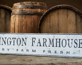 May include: White sign with black text that reads "Worthington Farmhouse Bakery - Farm Fresh" with decorative flourishes. The sign is in front of three wooden barrels.