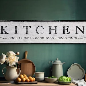 May include: White wooden sign with black lettering that reads "Kitchen - Good Friends - Good Food - Good Times".