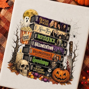 May include: A white canvas print featuring a stack of seven VHS tapes titled Hocus Pocus, The Addams Family, Beetlejuice, Halloweentown, Halloweentown II Kalabar's Revenge, Goosebumps, and The Nightmare Before Christmas, surrounded by a ghost, popcorn, skull, candle, knife, and pumpkin.