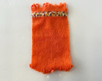 orange terrycloth washcloth with a decorative floral trim