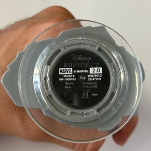 May include: A Disney Infinity Marvel 2.0 base with a clear plastic top. The base is gray with the Marvel logo and model information visible. The text "Disney Infinity" is also present.