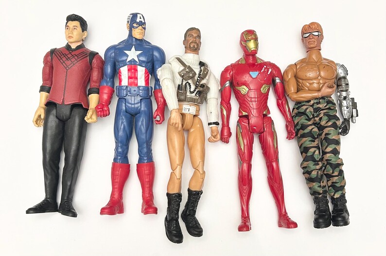 Op de afbeelding: Vijf actiefiguren van superhelden en personages, waaronder Captain America, Iron Man en anderen. De figuren zijn felgekleurd en gedetailleerd, met verschillende kostuums en accessoires. De figuren staan op een wit oppervlak.
