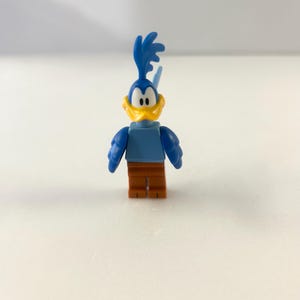 May include: A white ceramic mug with a black handle and the text "But First, Coffee" in a black, bold font. The mug is on a white surface. The mug appears to be empty.