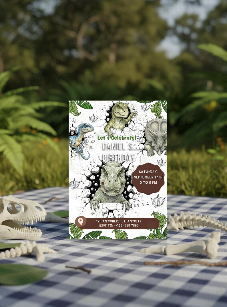 Pu&ograve; includere: Un invito di compleanno a tema dinosauri con illustrazioni di vari dinosauri che sfondano un muro. L'invito include il testo "Let's Celebrate! DANIEL S BIRTHDAY" e i dettagli dell'evento. L'invito &egrave; posto su una coperta da picnic a scacchi.