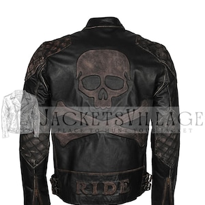 Könnte beinhalten: Schwarze Lederjacke mit Totenkopf- und gekreuzten Knochen-Design auf dem Rücken. Die Jacke hat gesteppte Schulterpartien, die Aufschrift "RIDE" und den Text "JACKETS VILLAGE PLACE TO HUNT YOUR JACKET".