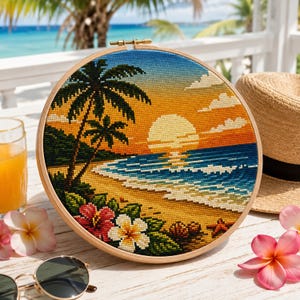 May include: A circular embroidery hoop featuring a cross-stitch design of a tropical beach at sunset. The scene includes palm trees, a bright yellow sun, blue ocean waves, a sandy shore, red and white hibiscus flowers, and a starfish.