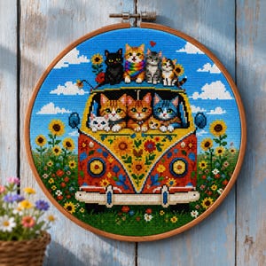 May include: A circular embroidery hoop containing a cross-stitch pattern of a colorful van decorated with floral motifs. Seven cats are positioned inside and on top of the van. The scene is set against a blue sky with clouds and sunflowers.