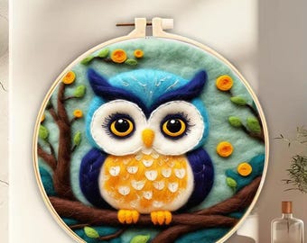 May include: A blue and yellow felt owl with large eyes, perched on a branch with green leaves and yellow flowers, in a round wooden embroidery hoop.