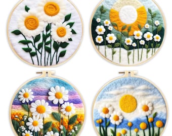 May include: Four embroidery hoops with needle felted daisy flower designs. The hoops are made of wood and have a gold finish. The designs include a cluster of daisies, a field of daisies with a yellow sun, a field of daisies with a rainbow sky, and a field of daisies with a blue sky and white clouds.