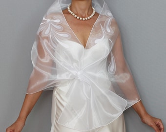 May include: White sheer shawl with a floral design. The shawl is tied in a bow at the front.