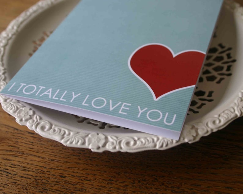 May include: A light blue card with a red heart and the text "I totally love you".