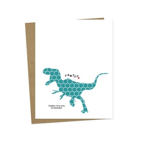 May include: A teal blue dinosaur silhouette with a honeycomb pattern and the word "rawrr" with a red heart. The text below the dinosaur says "means I love you in dinosaur".