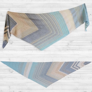 May include: A handmade, triangular shawl in shades of blue, beige, and gray. The shawl features a chevron design with alternating stripes of color and a delicate, openwork border. The soft, lightweight fabric is ideal for layering.