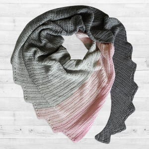 Puede incluir: Un chal de ganchillo hecho a mano en tonos grises y rosas. El chal presenta un efecto degradado, que va del gris al rosa. Los bordes tienen un diseño festoneado. El chal está hecho de hilo suave.
