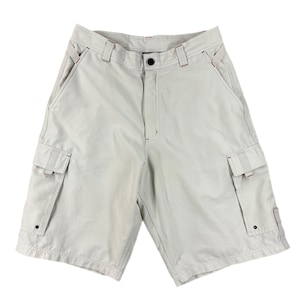 May include: Light grey cargo shorts with multiple pockets and red stitching details. The shorts feature a button fastening and are made from a lightweight fabric. These shorts are suitable for casual wear.