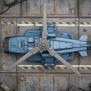Pu&ograve; includere: Vista aerea dettagliata di un modello di elicottero azzurro con un rotore a tre pale. Il modello &egrave; ambientato su uno sfondo metallico con strisce di pericolo gialle e nere, che suggeriscono un'officina o un hangar.
