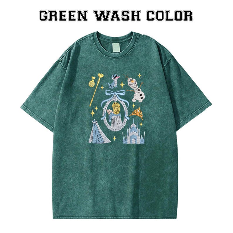 May include: Green wash colour t-shirt with a graphic featuring cartoon characters, a castle, and other elements. The shirt has a crew neck and short sleeves. The text "GREEN WASH COLOR" is at the top of the shirt.