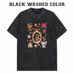 Pode incluir: T-shirt preto lavado com gola redonda. A camisa apresenta um design bordado colorido com um retrato de mulher, um barco, flores, estrelas e um porco. O texto "BLACK WASHED COLOR" est&aacute; no topo.