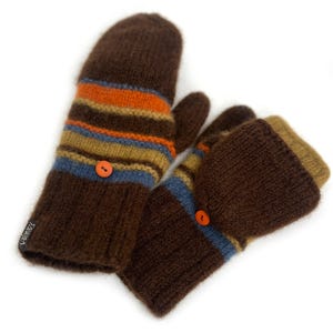 May include: A pair of brown knit convertible mittens featuring horizontal stripes in orange, tan, and blue. Each mitten has a small orange button to secure the fold-over flap and a black fabric tag with the white text "laine's" on the cuff.