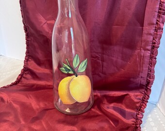 Botella de vidrio italiana vintage de 1 litro con diseño de melocotón y tapón de cerámica verde con cierre abatible.