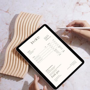 May include: A digital invoice on a tablet with the word "invoice" at the top. The invoice includes product details and a total. A wooden decorative piece and a stylus are also in the image.