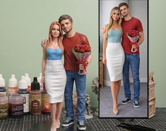 May include: A custom 3D figurine of a couple standing together, modelled after the framed photograph next to it. The female figure wears a blue strapless top and white skirt, while the male figure wears a red t-shirt, blue jeans, and holds a bouquet of red roses.