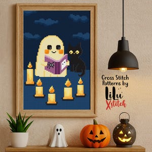 Puede incluir: Un patrón de punto de cruz enmarcado representa un fantasma leyendo un libro a un gato negro, rodeado de velas encendidas. La obra de arte está ambientada sobre un fondo azul oscuro con un marco de madera. El texto "Cross Stitch Patterns by lilu xStitch" es visible.