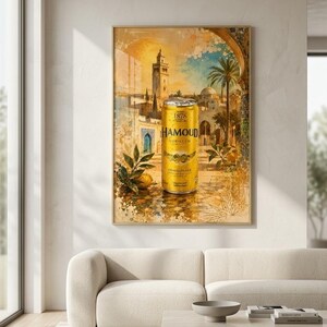Peut inclure: Une affiche murale encadrée représentant une canette de soda dorée Hamoud Boualem centrée sur une illustration style aquarelle d'un paysage urbain nord-africain avec un grand minaret, des palmiers et des feuilles d'agrumes avec un citron jaune.