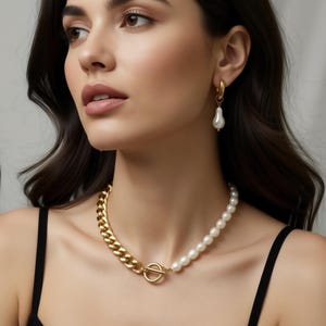 May include: A gold chain necklace with a pearl strand and a gold clasp. The necklace is paired with gold hoop earrings with a single pearl drop. The woman is wearing a black tank top.
