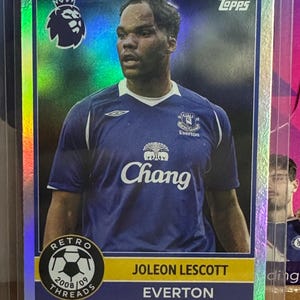 Puede incluir: Una tarjeta coleccionable Topps con Joleon Lescott con la camiseta del Everton. La tarjeta tiene un fondo holográfico con el logo de la Premier League y el escudo del Everton. También tiene el texto "Retro Threads 2008/09".
