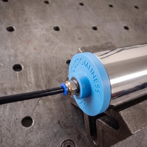 May include: A polished chrome cylindrical roller featuring a light blue plastic end cap with the text "CUSTOMLINESS" and "2.5"" embossed on the side. A black pneumatic tube is connected to a metal fitting centered on the blue end cap.