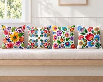 Peut inclure: Quatre coussins carrés disposés en rangée, chacun présentant un fond blanc avec des motifs floraux vibrants et multicolores. Les designs incluent diverses fleurs stylisées, des feuilles et des motifs botaniques complexes dans des tons de rouge, bleu, jaune, vert et violet.
