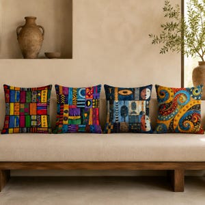Può includere: Quattro cuscini quadrati disposti in fila. Il primo presenta un motivo a griglia multicolore. Il secondo ha un vivace design patchwork. Il terzo mostra un pannello blu scuro con forme astratte. Il quarto mostra motivi vorticosi gialli e blu.