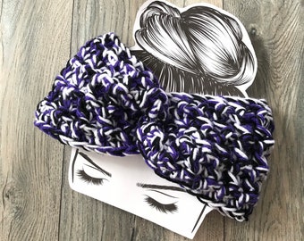 May include: Purple, black, and white crocheted headband with a textured design. The headband is displayed on a white card with a drawing of a woman's head.