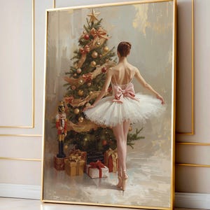 May include: A framed painting depicts a ballerina in a white tutu and pink bow, standing near a decorated Christmas tree. Gold ornaments, ribbons, and a star adorn the tree. A nutcracker and wrapped gifts are at the base.
