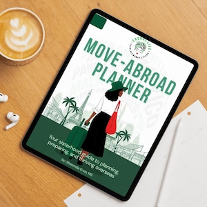 May include: A digital tablet displaying a "Move-Abroad Planner" graphic with a woman and luggage illustration. The tablet is on a wooden surface with a cup of coffee, wireless earbuds, and a charging case. The planner's text reads "Your sisterhood guide to planning, preparing, and thriving overseas."