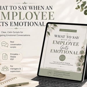 May include: A digital tablet shows the text "WHAT TO SAY WHEN AN EMPLOYEE GETS EMOTIONAL" in a green and white design. The image includes a coffee cup, notepad, and keyboard, suggesting a business or office setting. The tablet is propped up on a stand.