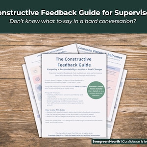 May include: A stack of white papers with the title "The Constructive Feedback Guide" and the text "Empathy, Accountability, Action = Real Change." The papers are on a wooden surface, with the text "Constructive Feedback Guide for Supervisors" at the top.
